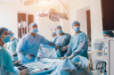 Surgeons look at a monitor while performing surgery