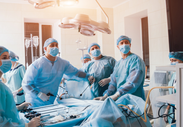 Surgeons look at a monitor while performing surgery