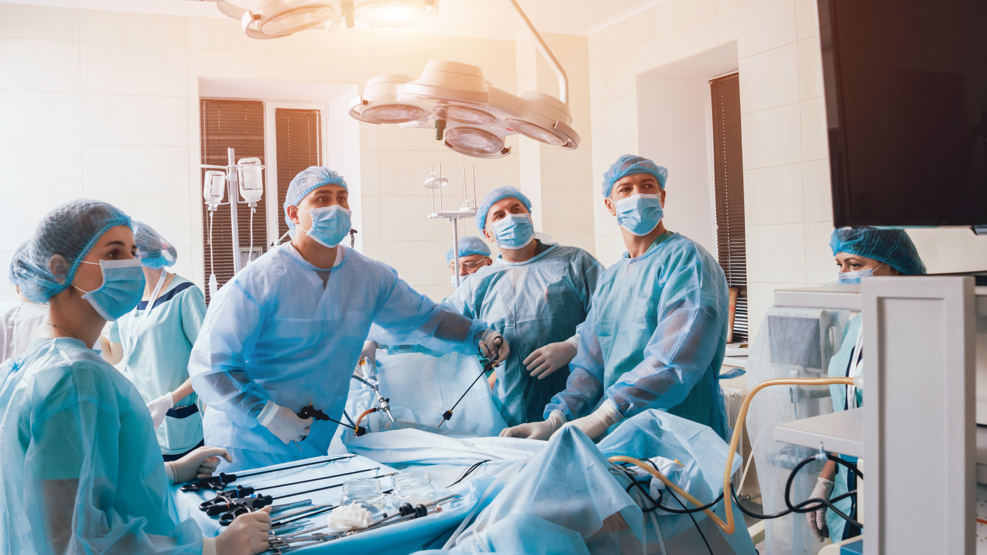 Surgeons look at a monitor while performing surgery